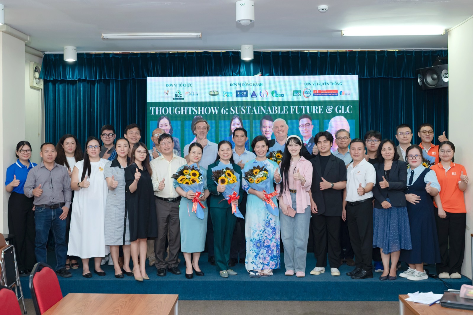 Khoảng ba mươi người tham dự chụp ảnh chung trên sân khấu trước phông nền Thoughtshow 6: Sustainable Future & GLC