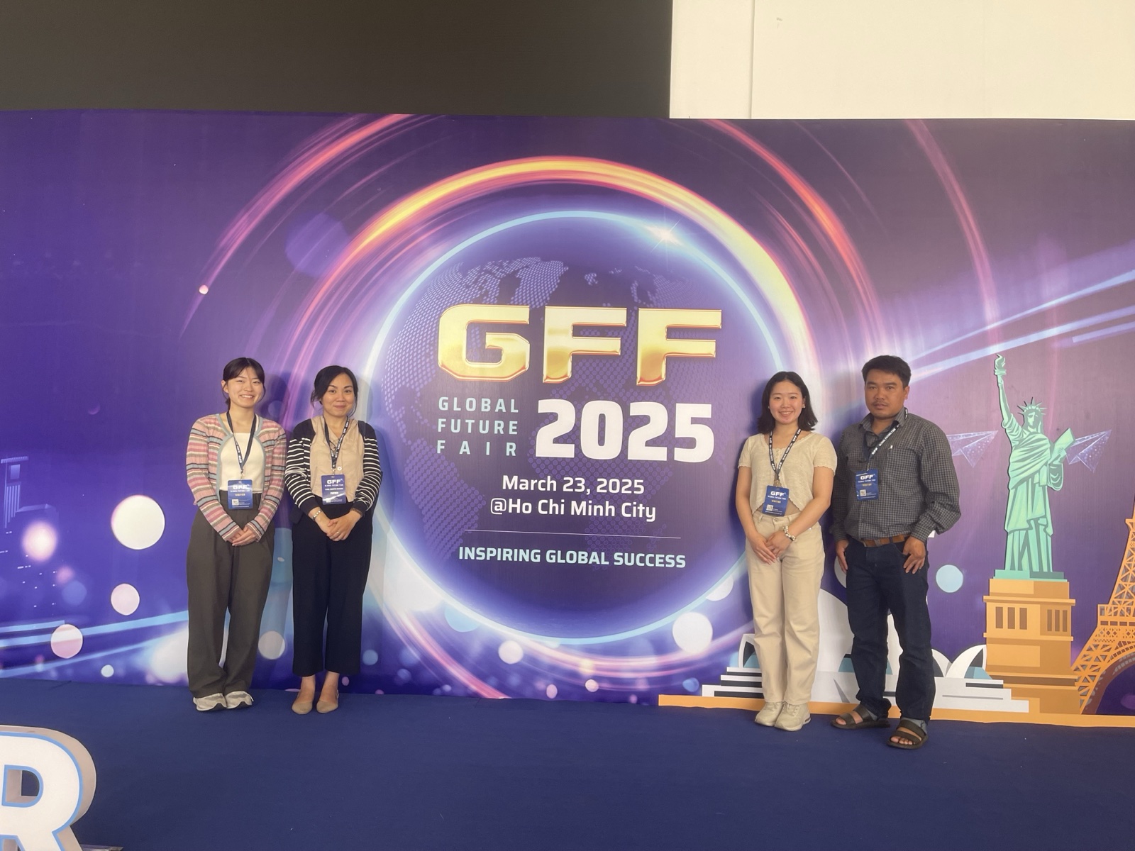 Bốn thành viên GLC chụp ảnh trước phông nền GFF 2025 ghi ngày 23 tháng 3 năm 2025 tại Thành phố Hồ Chí Minh