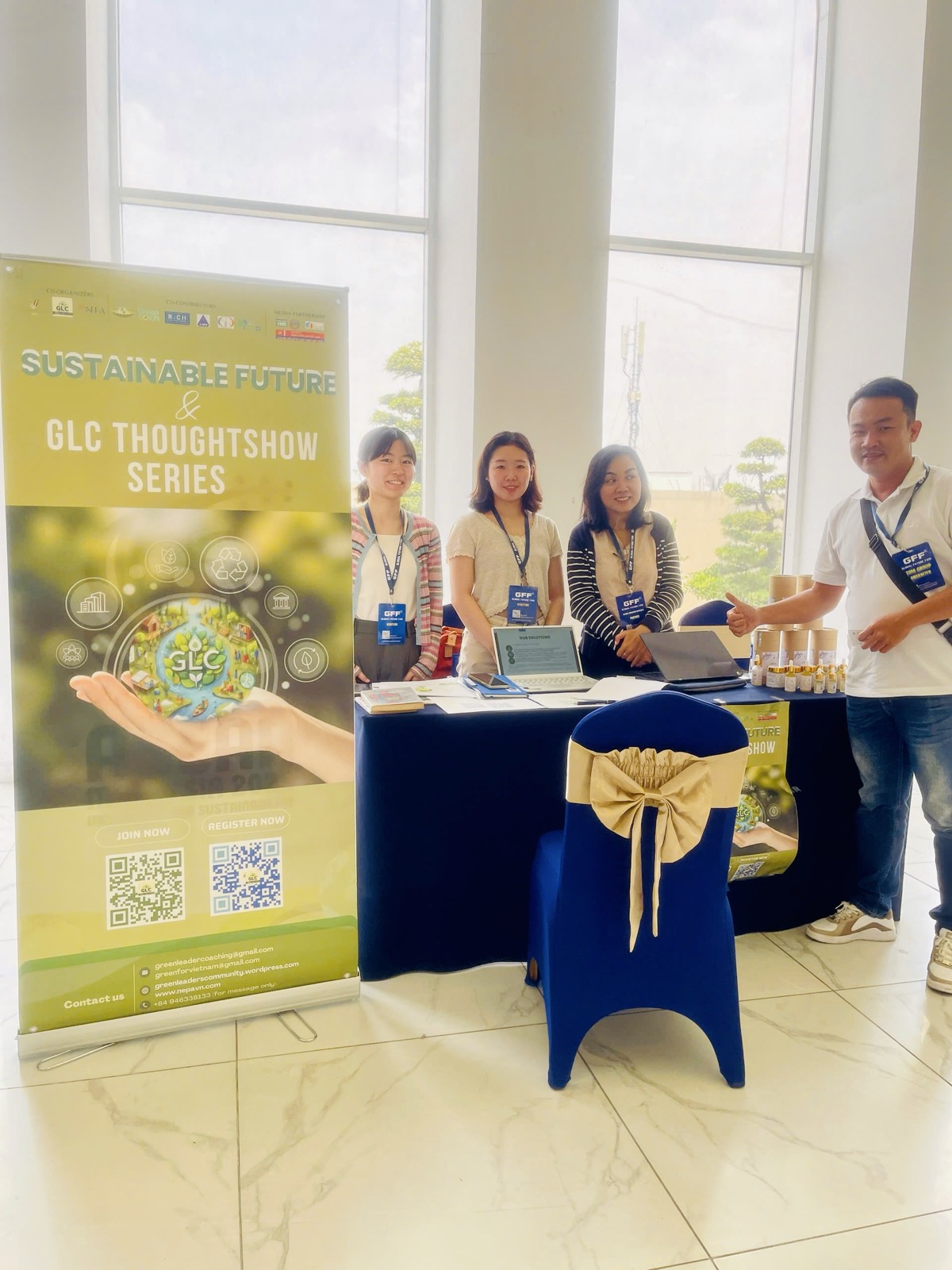 Bốn thành viên GLC đứng tại gian trưng bày bên cạnh standee Sustainable Future & GLC Thoughtshow Series