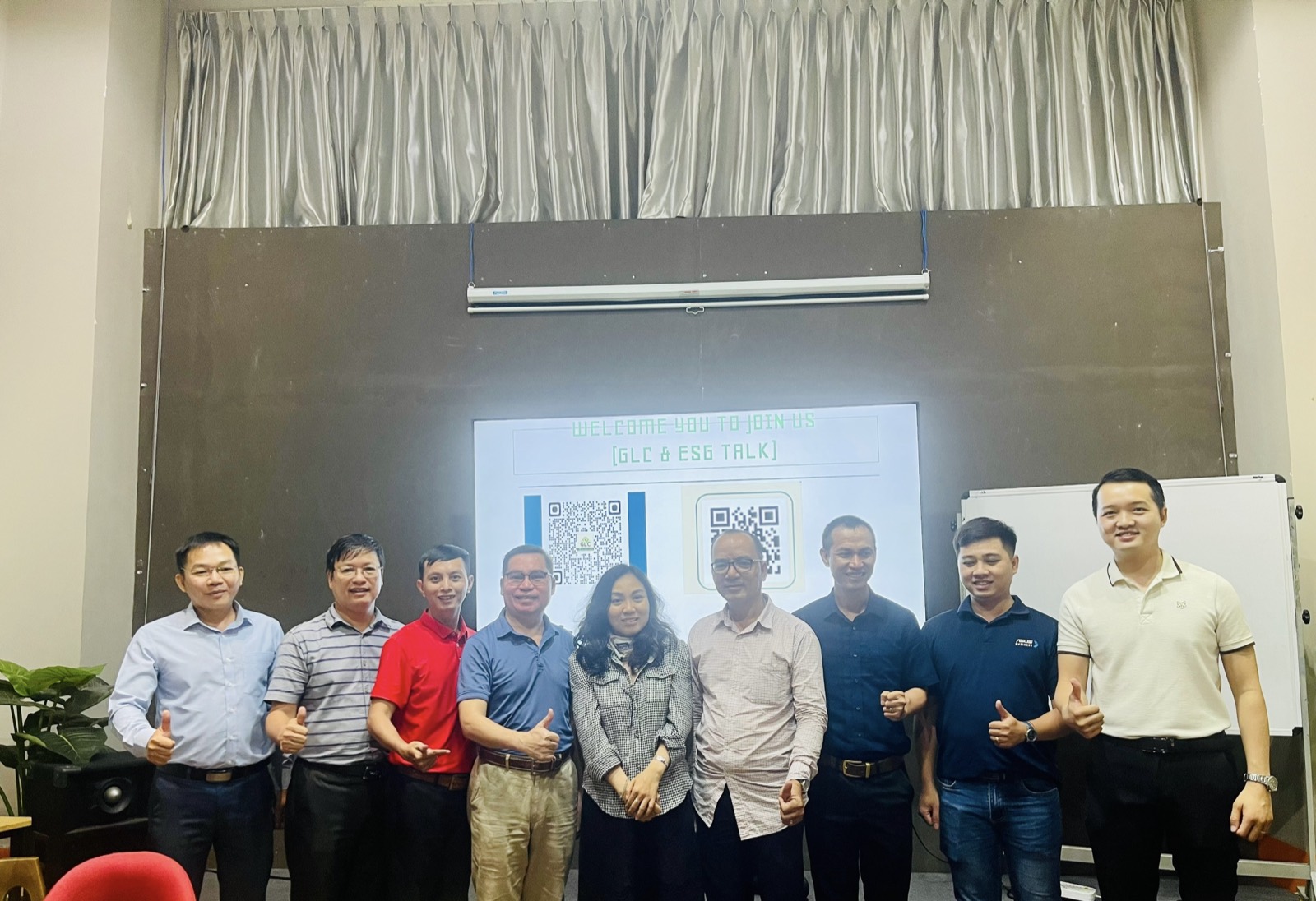 Nhóm người tham dự chụp ảnh trước màn chiếu có dòng chữ Welcome you to join us — GLC & ESG Talk